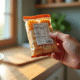 Main dans une cuisine moderne tenant un emballage alimentaire avec étiquette nutrition visible