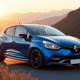 Renault Clio 2 RS bleue sur route de montagne au lever du soleil